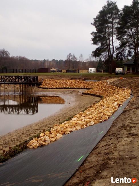 Kamień na skarpy brzegu stawu jeziora zbiornika wodnego