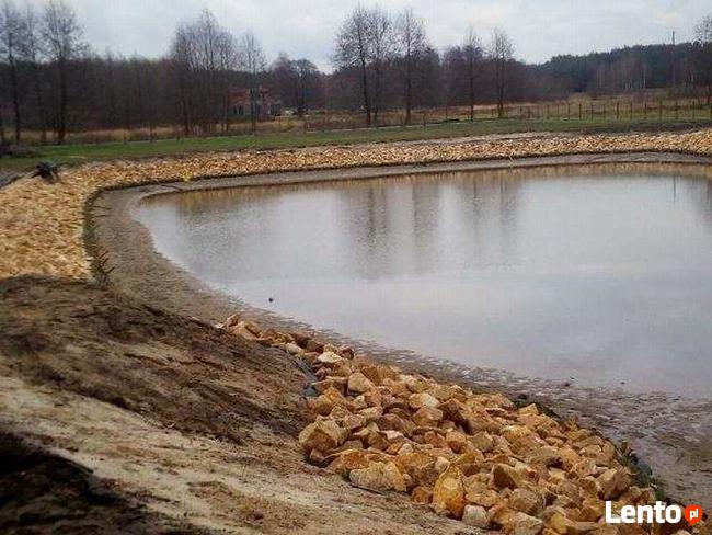 Kamień na skarpy brzegu stawu jeziora zbiornika wodnego