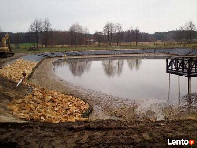Kamień na skarpy brzegu stawu jeziora zbiornika wodnego
