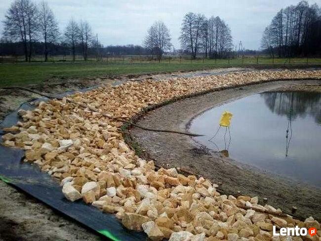 Kamień na skarpy brzegu stawu jeziora zbiornika wodnego