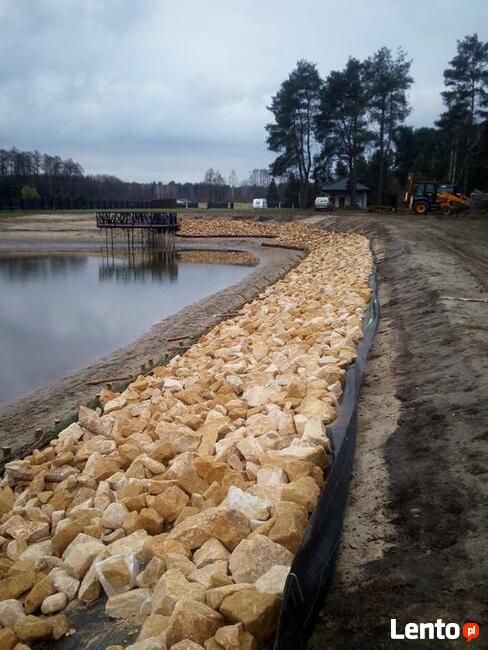 Kamień na skarpy brzegu stawu jeziora zbiornika wodnego
