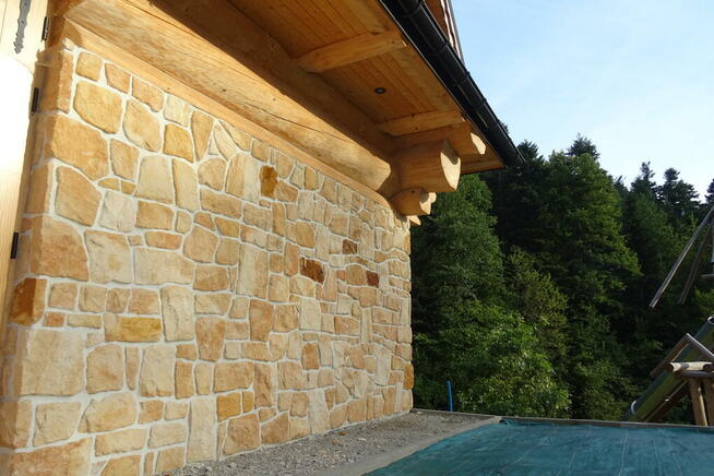 Płytki kamień naturalny elewacyjny na dom z bala drewna