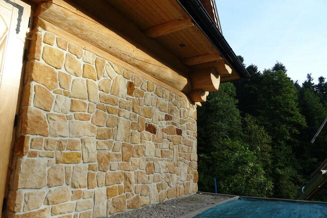 Płytki kamień naturalny elewacyjny na dom z bala drewna