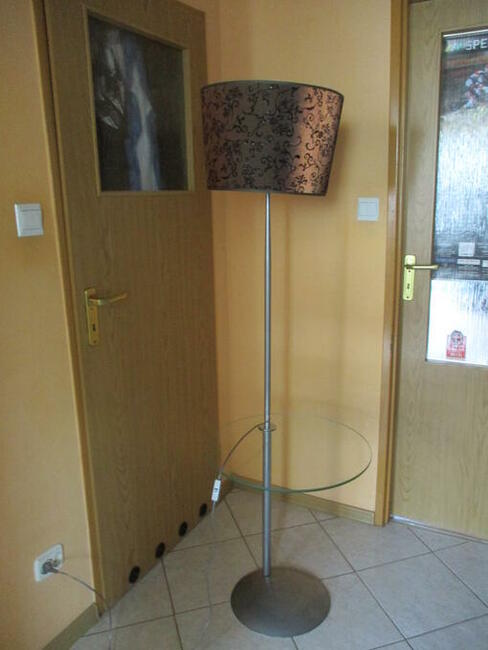 Lampa stojąca z półą szklaną.