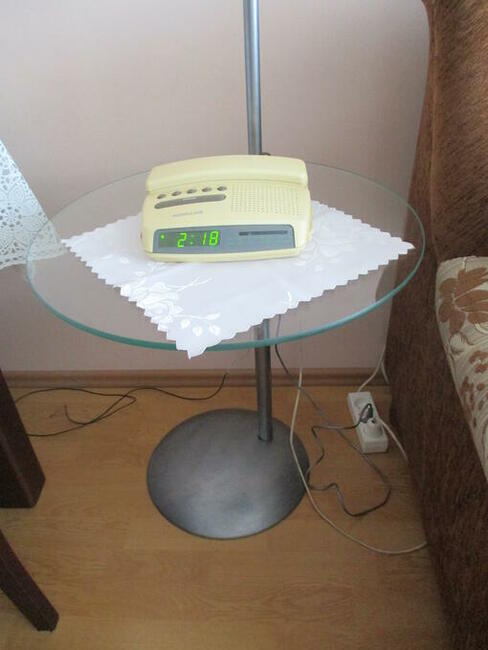 Lampa stojąca z półką szklaną.