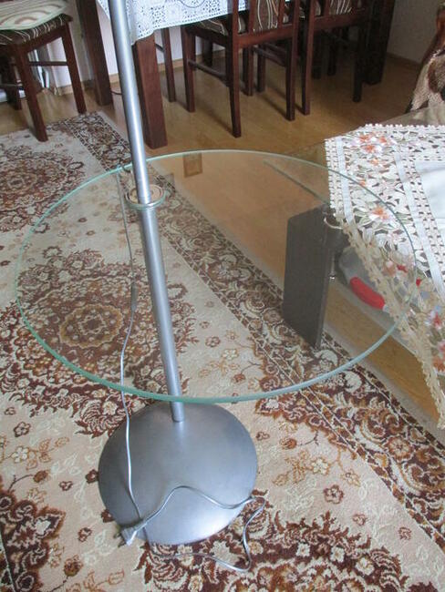 Lampa stojąca z półką szklaną.