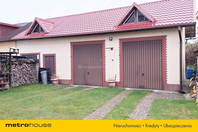 Dom w zabudowie bliźniaczej z dwoma garażami.