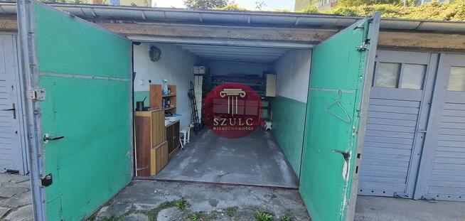 Funkcjonalny garaż z regałami i oświetleniem.