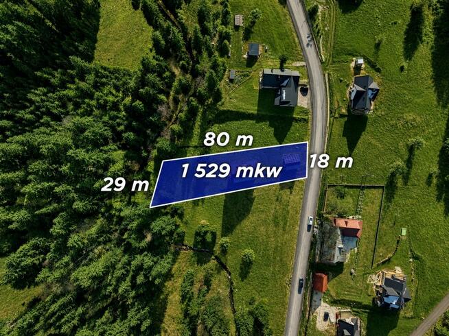 Dom jednorodziny z wiatą w otoczeniu lasu i potoku