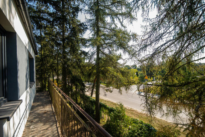 Dom wolnostojący w otoczeniu drzew. Zakroczym.