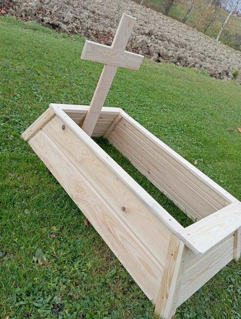 Tymczasowa obudowa nagrobka dla dziecka z krzyżem.