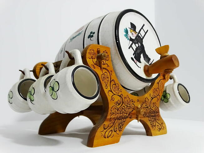 Dystrybutor w kształcie beczki, osadzony na rzeźbionym stoja