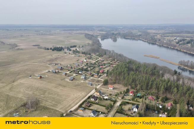 Działka rekreacyjna nad jeziorem blisko lasu.