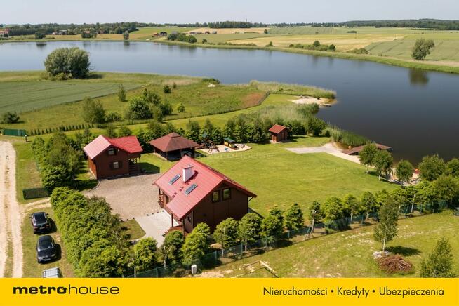 Dwa domki rekreacyjne na działce z linią brzegową.