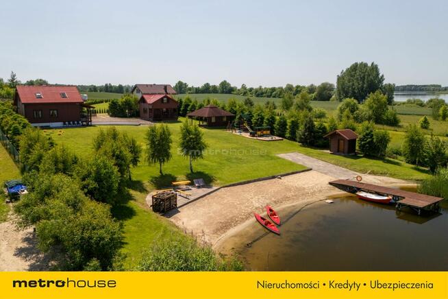 Dwa domki rekreacyjne na działce z linią brzegową.