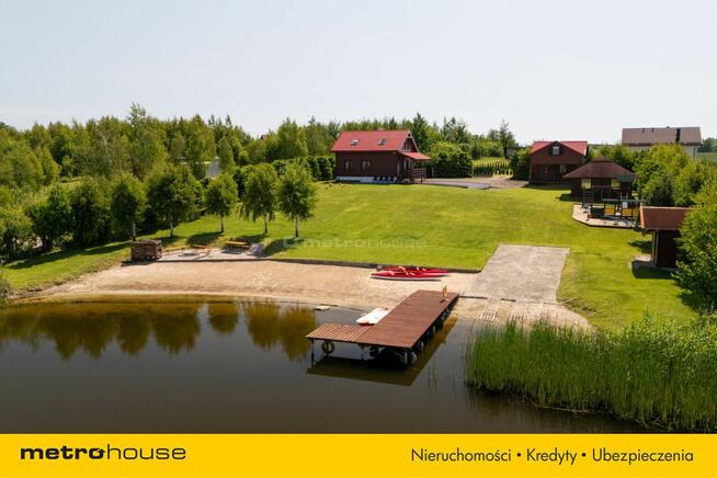 Dwa domki rekreacyjne na działce z linią brzegową.