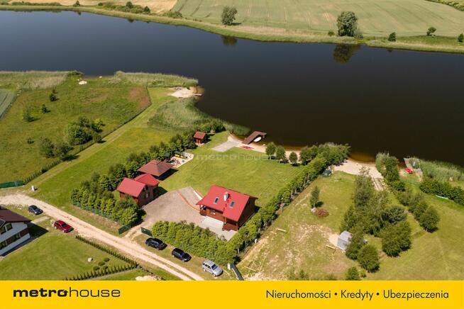 Dwa domki rekreacyjne na działce z linią brzegową.