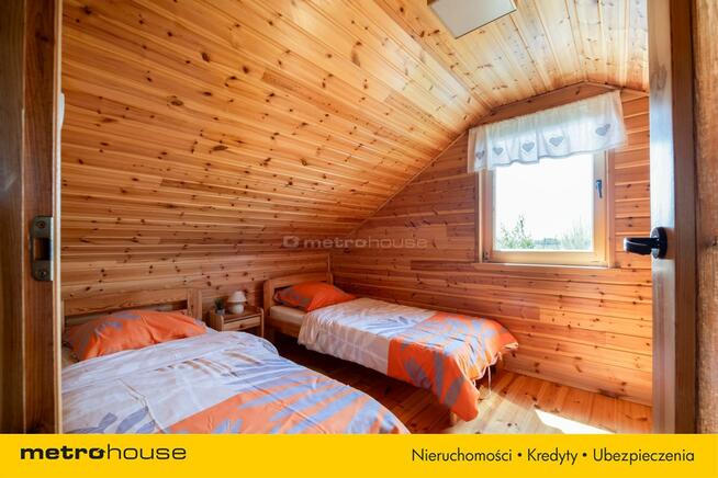 Dwa domki rekreacyjne na działce z linią brzegową.