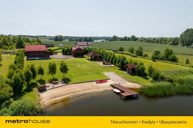 Dwa domki rekreacyjne na działce z linią brzegową.