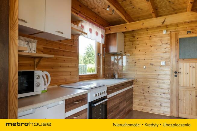 Dwa domki rekreacyjne na działce z linią brzegową.