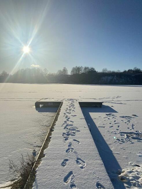 Domek z linia brzegową oraz pomostem nad jeziorem Kopiec