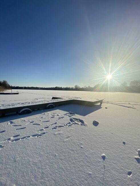 Domek z linia brzegową oraz pomostem nad jeziorem Kopiec