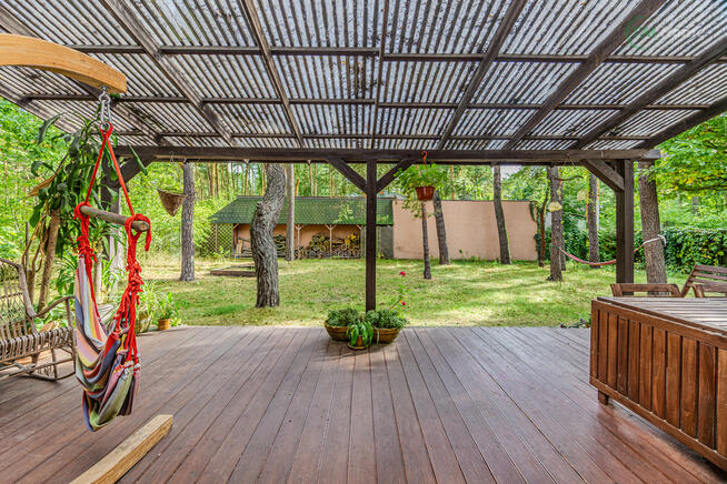 Józefów, dom wolnostojący otoczony sosnami.