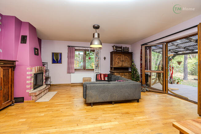 Józefów, dom wolnostojący otoczony sosnami.