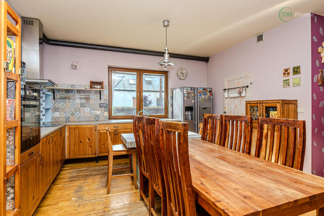 Józefów, dom wolnostojący otoczony sosnami.