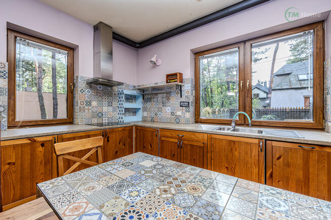 Józefów, dom wolnostojący otoczony sosnami.