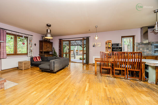 Józefów, dom wolnostojący otoczony sosnami.