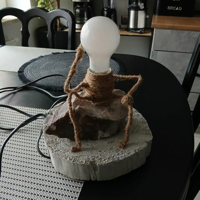 Lampka stołowa myśliciel siedzący na kamieniu