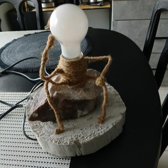 Lampka stołowa myśliciel siedzący na kamieniu