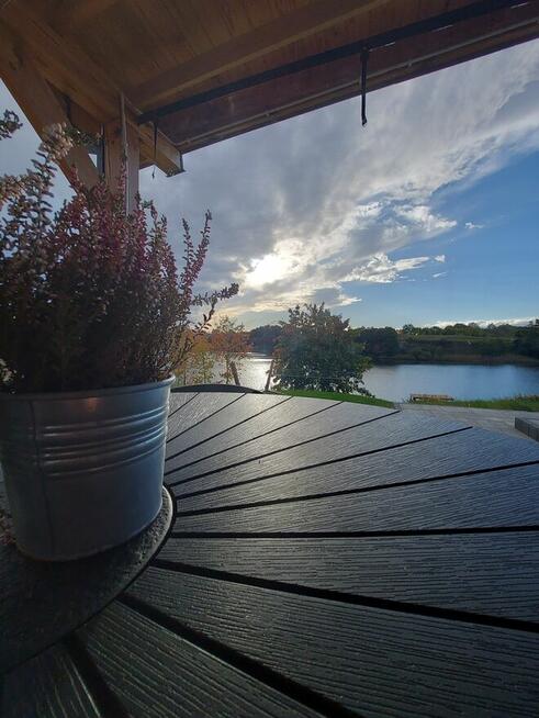 Domek z linia brzegową oraz pomostem nad jeziorem Kopiec