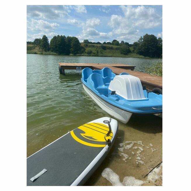 Domek z linia brzegową oraz pomostem nad jeziorem Kopiec