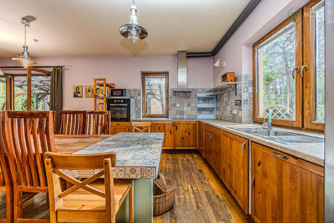 Józefów, dom wolnostojący otoczony sosnami.