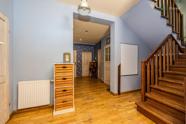 Józefów, dom wolnostojący otoczony sosnami.