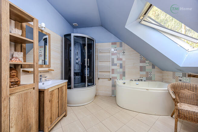 Józefów, dom wolnostojący otoczony sosnami.