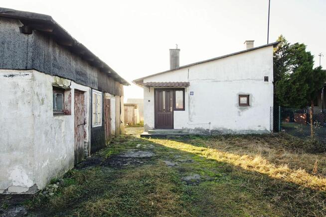 Mały dom z budynkiem gospodarczym.